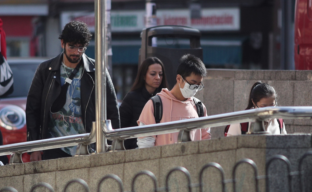 Peatones con mascarillas por coronavirus en el metro de Madrid