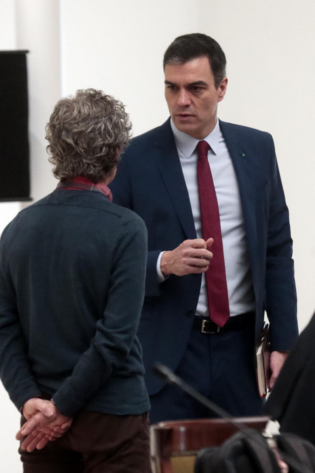 El presidente del Gobierno, Pedro Sánchez, conversa con el director del Centro de Coordinación de Alertas y Emergencias Sanitarias del Ministerio, Fernando Simón (de espaldas), antes de la reunión del Comité Técnico de Gestión del COVID-19 el mismo día en