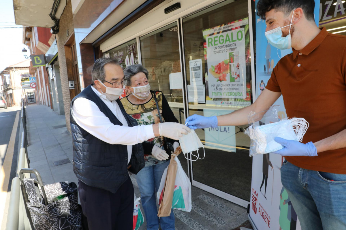 Reparto a dos clienes de mascarillas a la puerta de un Supermercado en Algete (Madrid)