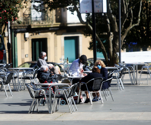 Comensales disfrutan en la terraza de un restaurante con un 30% de aforo permitido en el área sanitaria de Ferrol.