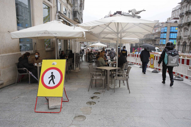 Varias personas en una terraza, el día en que entran en vigor nuevas medidas en la hostelería, en Vigo, Pontevedra, Galicia, (España)