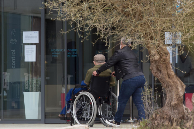 Archivo - Una mujer pasea junto a un anciano en silla de ruedas hacia la residencia Albertia, a 17 de abril de 2021, en Lugo, Galicia (España). Una de las nuevas medidas incluidas en la desescalada de Galicia consiste en la ampliación de las posibilidades