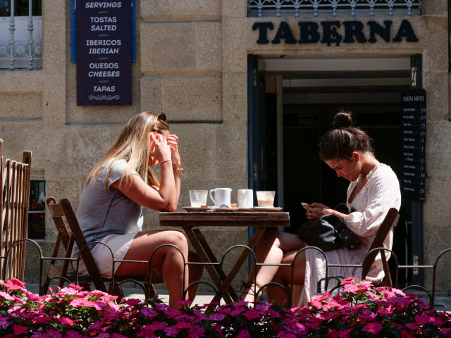 Archivo - Dos mujeres en la terraza de un restaurante de la Rua da Raiña, a 12 de agosto de 2021, en Santiago de Compostela