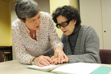 Una profesora de braille enseña a leer con las manos a una mujer ciega