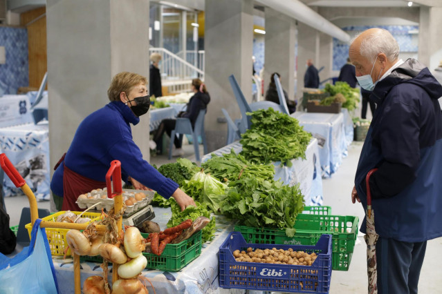 Una vendedora local de verduras y productos del campo vende sus productos en el mercado tradicional de la Plaza de Abastos de Lugo, a 22 de marzo de 2022, en Lugo, Galicia (España). El paro convocado a nivel nacional por la Plataforma para la Defensa del