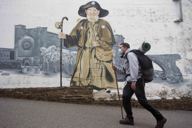 Archivo - Gabriel, un peregrino madrileño que realiza por segunda vez el Camino de Santiago y pasa por delante del mural del Zapatones, en la ruta del Camino de Santiago francés.