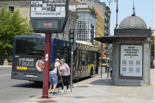 Dos personas se saludan al lado de un termómetro en la calle que marca 41 grados, a 12 de julio de 2022, en Orense, Galicia (España). Los termómetros de la práctica totalidad del territorio gallego alcanzarán valores “extremos” debido a la ola de calor qu