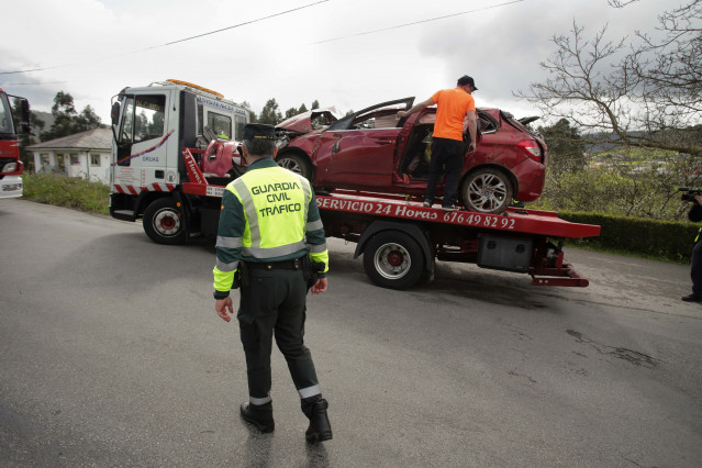 Archivo - Un Guardia Civil vigila la retirada del coche siniestrado, en el accidente, por una grúa, a 1 de abril de 2023, en Xove, Lugo, Galicia, (España). Dos hombres y dos mujeres, vecinos de Ribadeo, han fallecido en un accidente de circulación registr