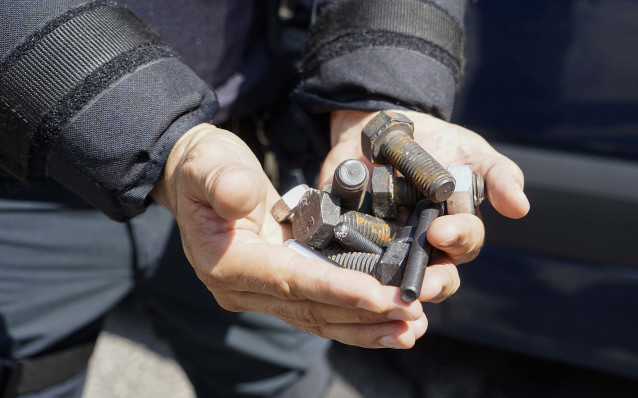 Un hombre muestra tornillos que los trabajadores del metal han tirado a la Policía durante una manifestación en Vigo.