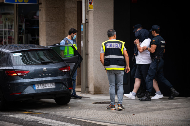 Agentes de policía trasladan a un detenido durante un operativo policial en Rúa do Progreso, a 1 de agosto de 2023, en Sanxenxo.