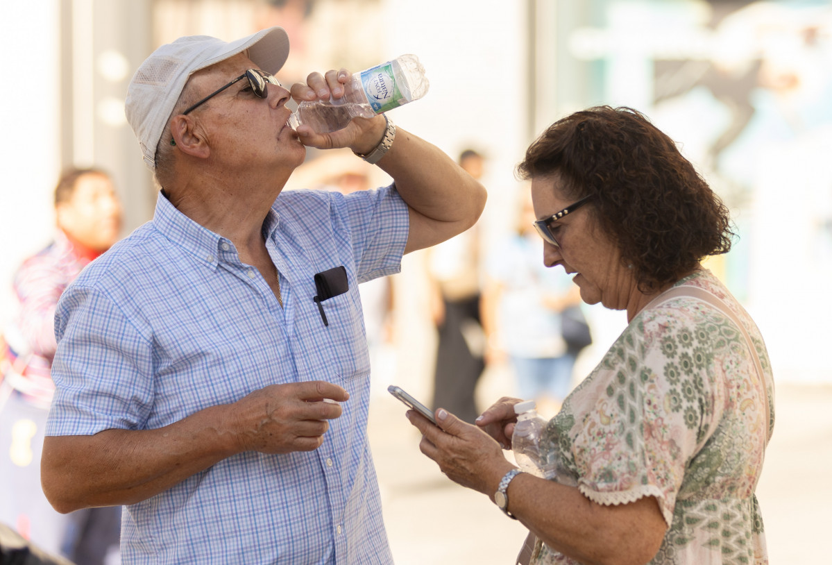 Una persona bebe agua para refrescarse ante las altas temperaturas, a 6 de octubre de 2023, en Madrid.