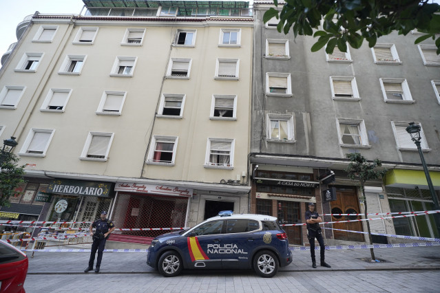 Un vehículo y dos agentes de Policía Nacional frente al edificio donde se ha producido un incendio en la calle Alfonso X el Sabio de Vigo, a 11 de octubre de 2023, en Vigo, Pontevedra, Galicia (España).