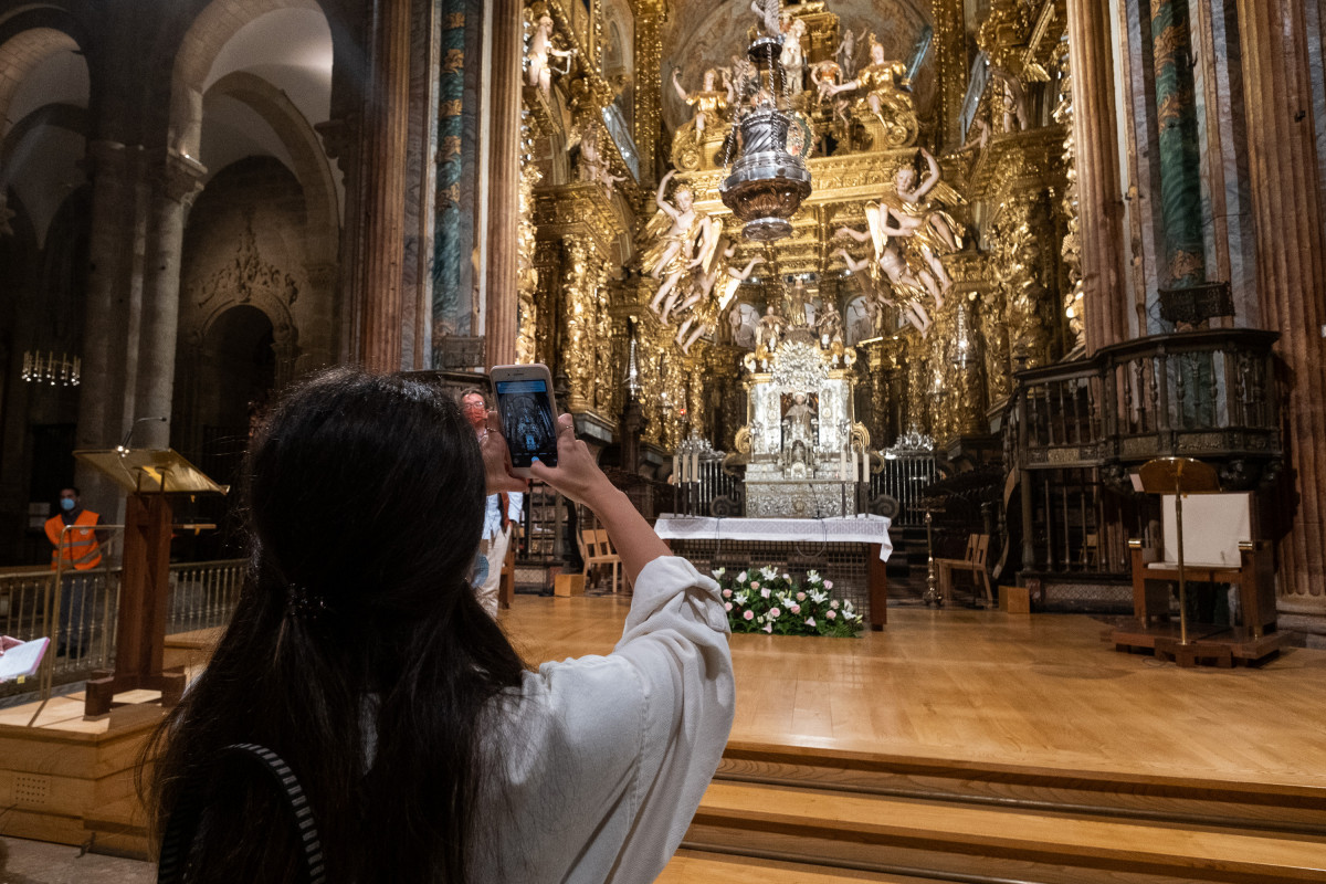 Archivo - Una mujer toma una fotografía durante una visita guiada nocturna en la Catedral de Santiago, a 10 de agosto de 2021, en Santiago de Compostela, A Coruña, Galicia (España). La Fundación C