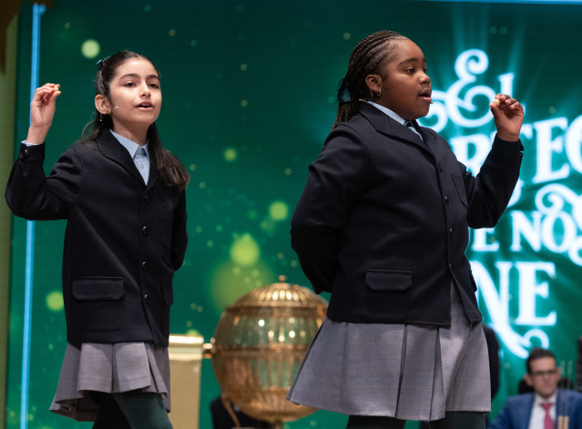 Rosario Martínez Garía (i), y Ainhoa Rosero Gómez (d) cantan el tercer premio, el número 31938, durante el Sorteo Extraordinario de la Lotería de Navidad 2023 en el Teatro Real de Madrid, a 22 de diciembre de 2023, en Madrid (España). El sorteo se celebra