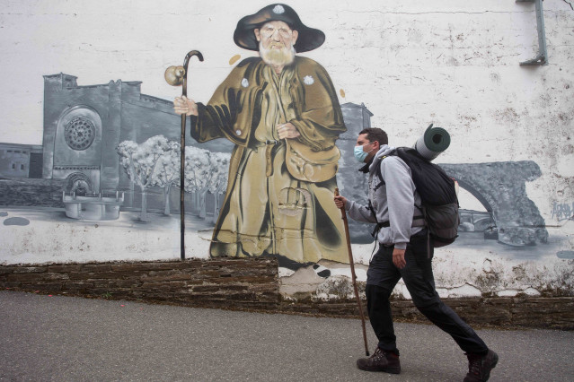 Archivo - EP- Selección fotos 2021: Gabriel, un peregrino madrileño que realiza por segunda vez el Camino de Santiago y pasa por delante del mural del Zapatones, en la ruta del Camino de Santiago francés, a 17 de junio de 2021, en Lugo