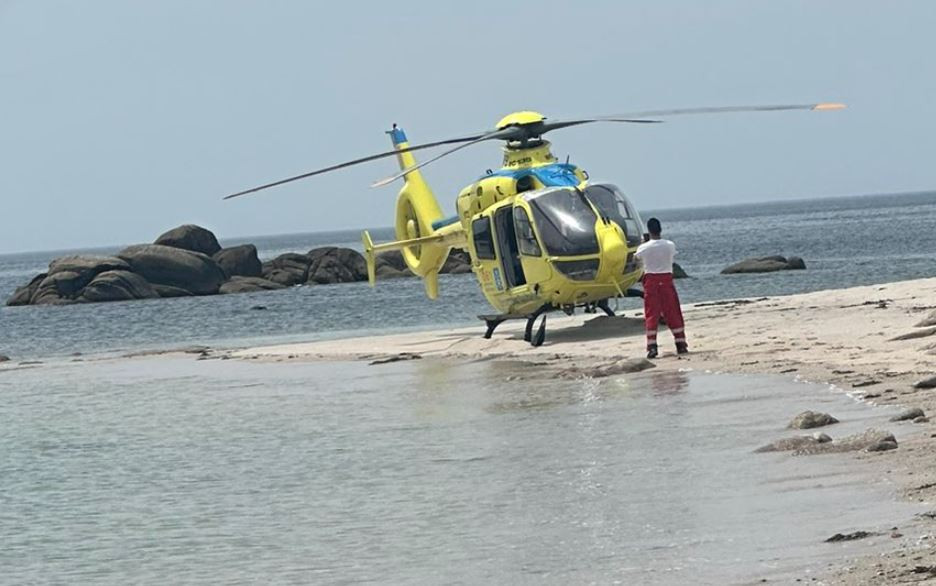 El helicu00f3ptero del 061 en la playa de Carnota tras intentar rescatar al ahogado en una foto de @HelicoSantiago