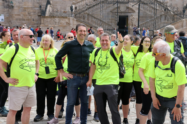 El conselleiro do Mar, Alfonso Villares,  recibe a un grupo de peregrinos en el Obradoiro.