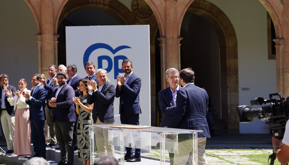 El presidente del PP, Alberto Núñez Feijóo (2d), junto al presidente de Castilla y León, Alfonso Fernández Mañueco (1d), se dan la manos tras una reunión para abordar la EBAU única.