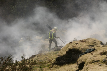Archivo - Dos brigadistas forestales trabajan para extinguir las llamas en un incendio forestal, a 30 de marzo de 2023, en Baleira, Lugo, Galicia (España). El incendio forestal declarado en Baleira (