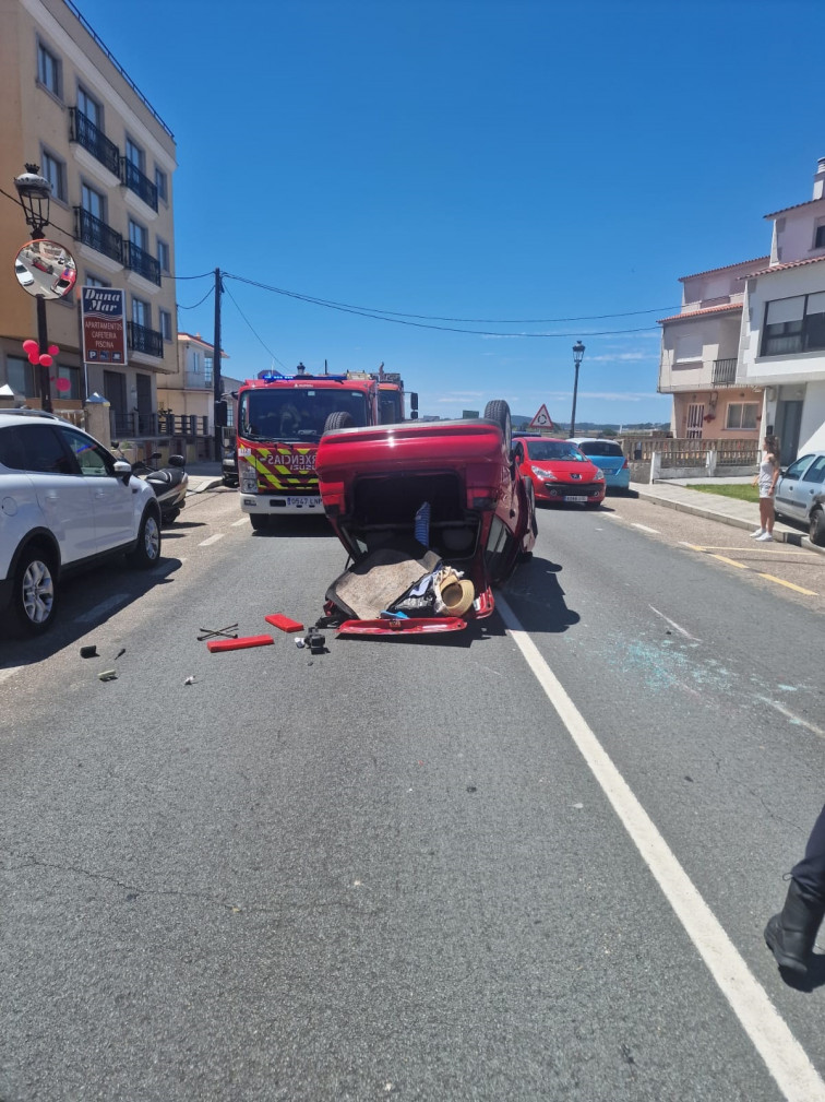 Un espectacular accidente en Sanxenxo deja un coche panza arriba y destrozos en dos vehículos estacionados