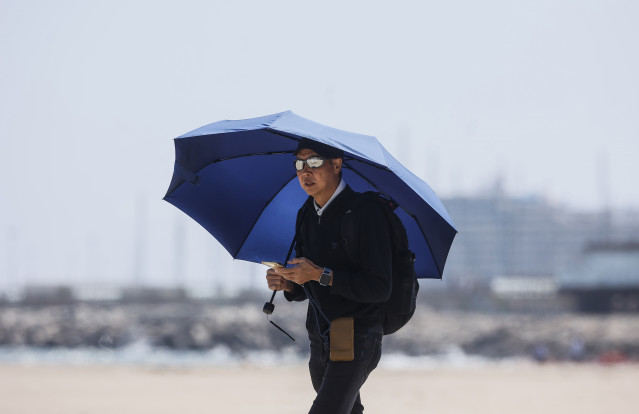 Archivo - Un hombre camina por la playa de la Malvarrosa, a 26 de abril de 2023, en Valencia, Comunidad Valenciana (España). Las temperaturas en la Comunitat Valenciana alcanzarán esta semana valores propios de verano, con máximas que podrían superar los