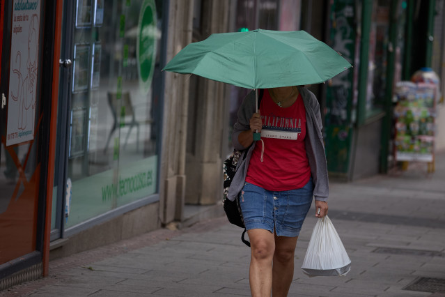 Archivo - Una mujer se protege de la lluvia con un paraguas, a 8 de junio de 2024, en Madrid (España).