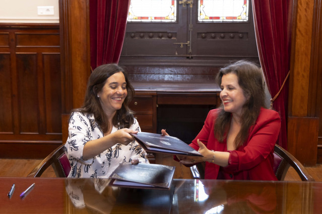 La alcaldesa de A Coruña, Inés Rey, y la presidenta de la junta rectora de la Comunidad de Propietarios del polígono de Pocomaco, Lucía López, firman un convenio de colaboración