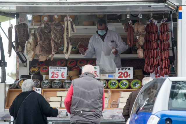 Archivo - Un hombre y una mujer compran en un mercadillo de Castro Riberas de Lea, Galicia (España) a 27 de enero de 2021. A las 00,00 de este miércoles han entrado en vigor las nuevas restricciones implantadas por la Xunta para luchar contra la pandemia