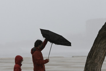 Archivo - Dos personas caminan en la zona de las Esclavas, en A coruña, un día de temporal