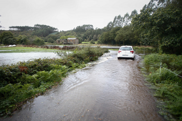 Un coche circula por un camino anegado por el desbordamiento del río Anllo, a 9 de octubre de 2024, en A Veiga, en Moncelos (Abadín).