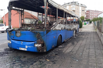 Autobús de la empresa Alsa calcinado tras un incendio en Cerceda, en el que también sufrió daños por fuego otro autocar  de la misma empresa estacionado cerca.