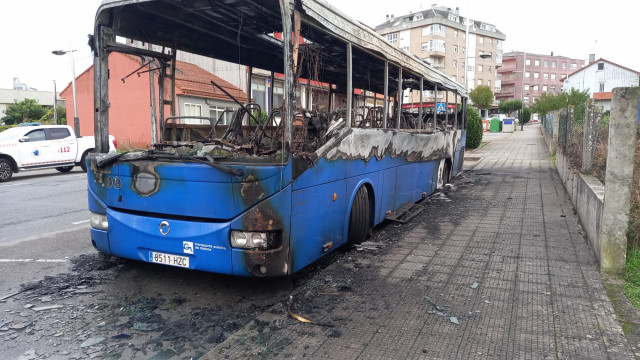 Autobús de la empresa Alsa calcinado tras un incendio en Cerceda, en el que también sufrió daños por fuego otro autocar  de la misma empresa estacionado cerca.