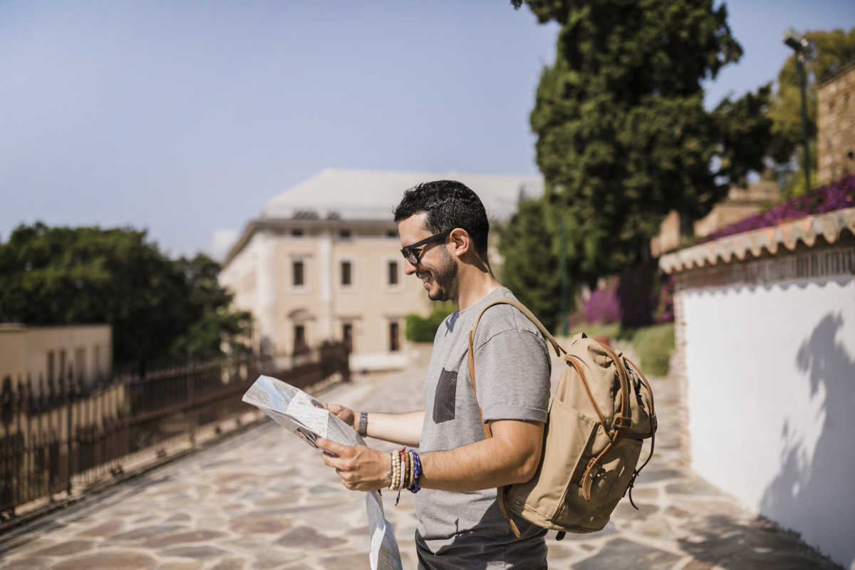 Side view smiling man looking map standing street