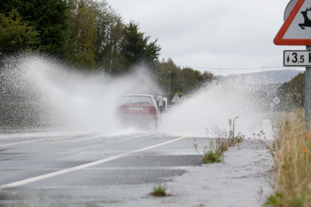 Un coche circula por una carretera anegada por el desbordamiento del río Anllo, a 9 de octubre de 2024, en O Santo, Vilalba, Lugo, Galicia (España). La Agencia Estatal de Meteorología (AEMET) ha puesto a Galicia en alerta naranja por la borrasca Kirk, que