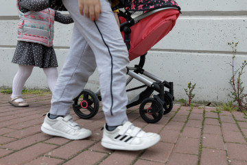 Archivo - Una niña pasea por la calle empujando un carrito con un bebé de juguete junto a su padre y su hermano durante el segundo día de desconfinamiento de niños y preadolescentes durante el est