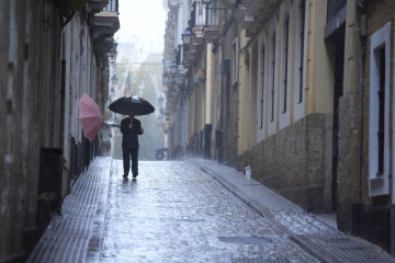 Transeuntes bajo sus paraguas durante la intensa lluvia.