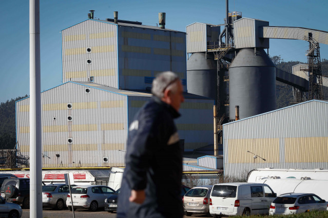 Archivo - Un trabajador  frente a las instalaciones de la factoría de aluminio de Alcoa en San Cibrao, Cervo (Lugo)