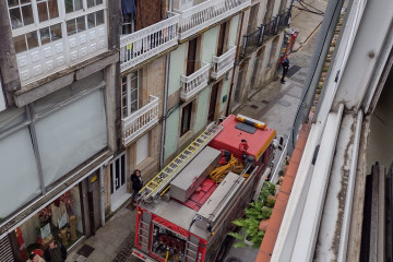 Bomberos del parque comarcal de Boiro extinguen las llamas en una terraza exterior de un edificio en Rianxo.