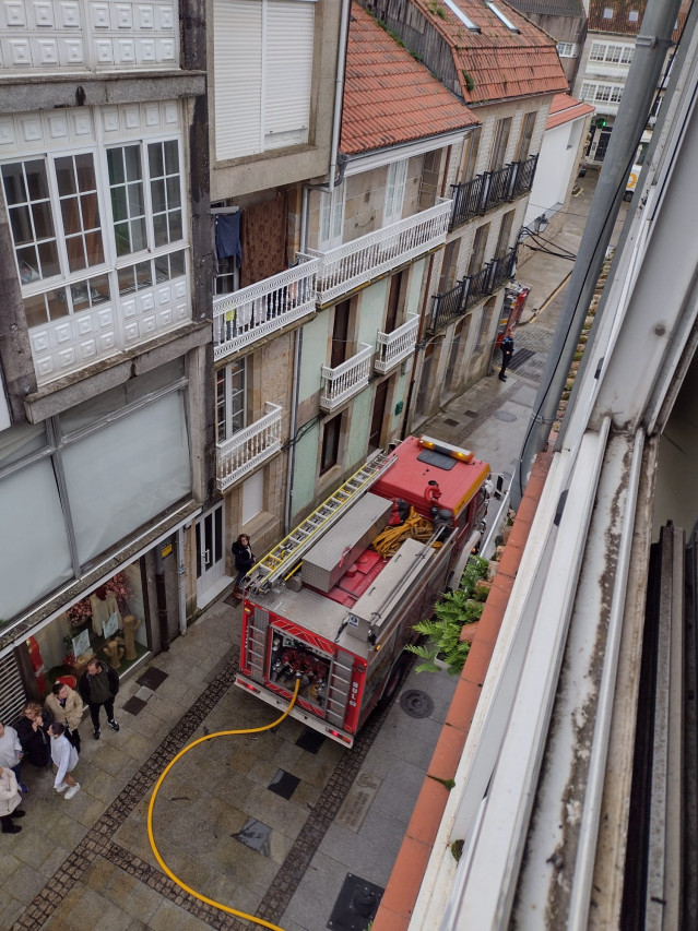 Bomberos del parque comarcal de Boiro extinguen las llamas en una terraza exterior de un edificio en Rianxo.