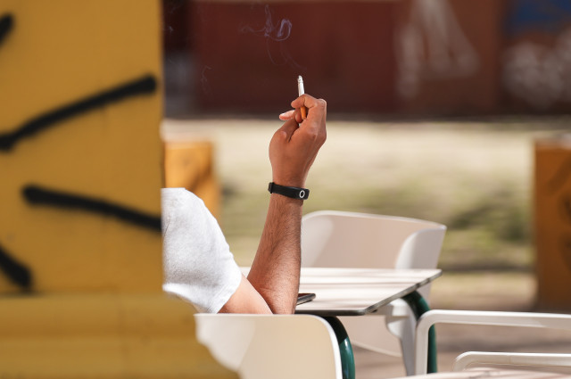 Archivo - Una persona fumando en una terraza. A 12 de marzo de 2024, en Sevilla (Andalucía, España).