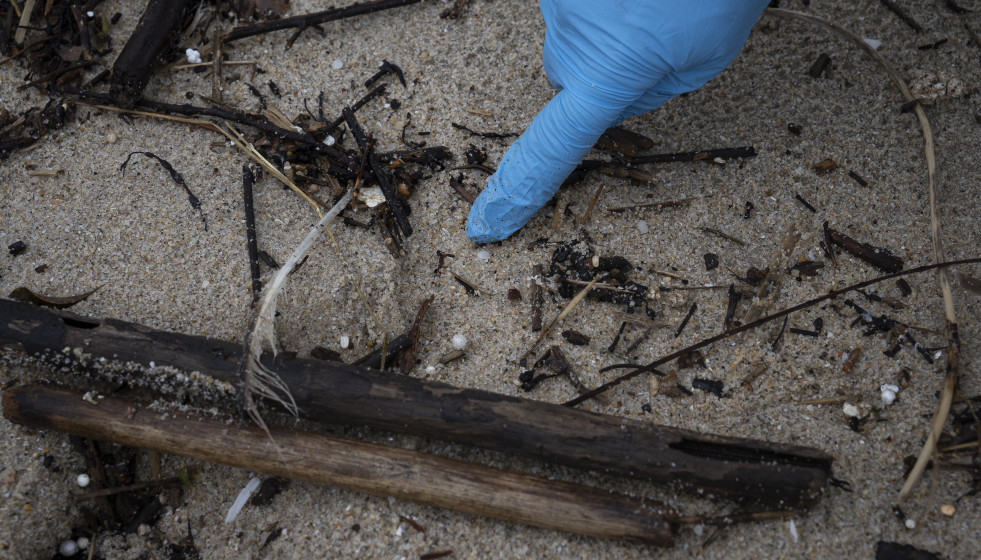 Archivo - Un voluntario recoge pellets en la playa de Samil, a 10 de enero de 2024, en Vigo, Pontevedra, Galicia (España).