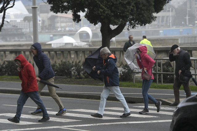 Archivo - Varias personas se protegen de la lluvia y el viento con paraguas, a 20 de octubre de 2023, en A Coruña, Galicia (España). La Xunta ha activado para hoy la alerta roja por temporal costero en el litoral Norte y Noroeste de la provincia de A Coru