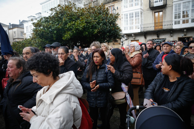 Varias personas durante un minuto de silencio por el asesinato machista de Rejane, de 42 años, frente al Concello de Viveiro, a 19 de diciembre de 2024, en Viveiro, Lugo, Galicia (España). La mujer de origen brasileño fue asesinada ayer con un arma blanca