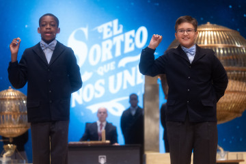 Adam Lucas Kadmiri (i) y Sergio Abaga (d), cantan un quinto premio, el número 37.876 durante la celebración del Sorteo Extraordinario de la Lotería de Navidad 2024, en el Teatro Real, a 22 de dicie