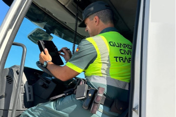 Archivo - Un guardia civil analiza la tarjeta de un tacógrafo.