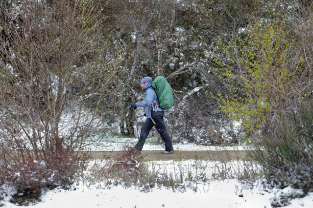 Archivo - Una peregrina realiza el Camino de Santiago entre la nieve, a 20 de abril de 2022, en O Cebreiro, Lugo, Galicia (España). Después de una Semana Santa con altas temperaturas y en mitad de la primavera, Galicia vuelve al invierno con temperaturas