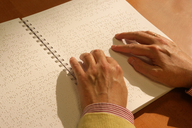 Archivo - Una persona leyendo braille