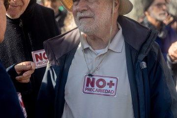 Un hombre lleva una pegatina en la que se lee 'No + precariedad' durante una concentración convocada por la plataforma RMI Tu Derecho (Renta Mínima de Inserción), frente al Ministerio de Inclusión