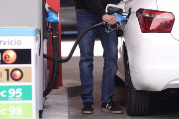 Archivo - Un hombre inyecta carburante a su coche.