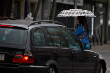 Archivo - Una mujer se protege de la lluvia con un paraguas, a 8 de junio de 2024, en Madrid (España). La llegada de una Depresión Aislada en Niveles Altos (DANA) a España va a provocar durante el 